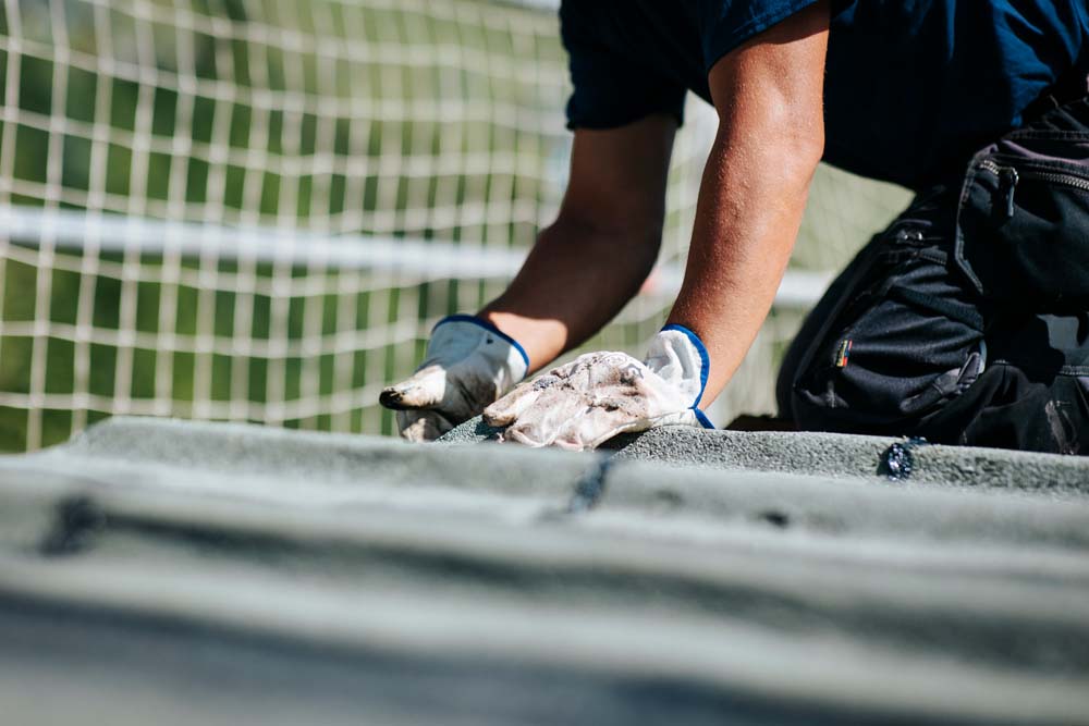 Un homme réalise des travaux d'étanchéité sur le toit d'un bâtiment