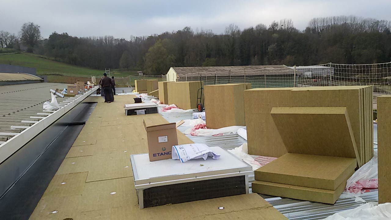 Des panneaux de mousse isolante sont disposés sur le toit en attendant leur installation